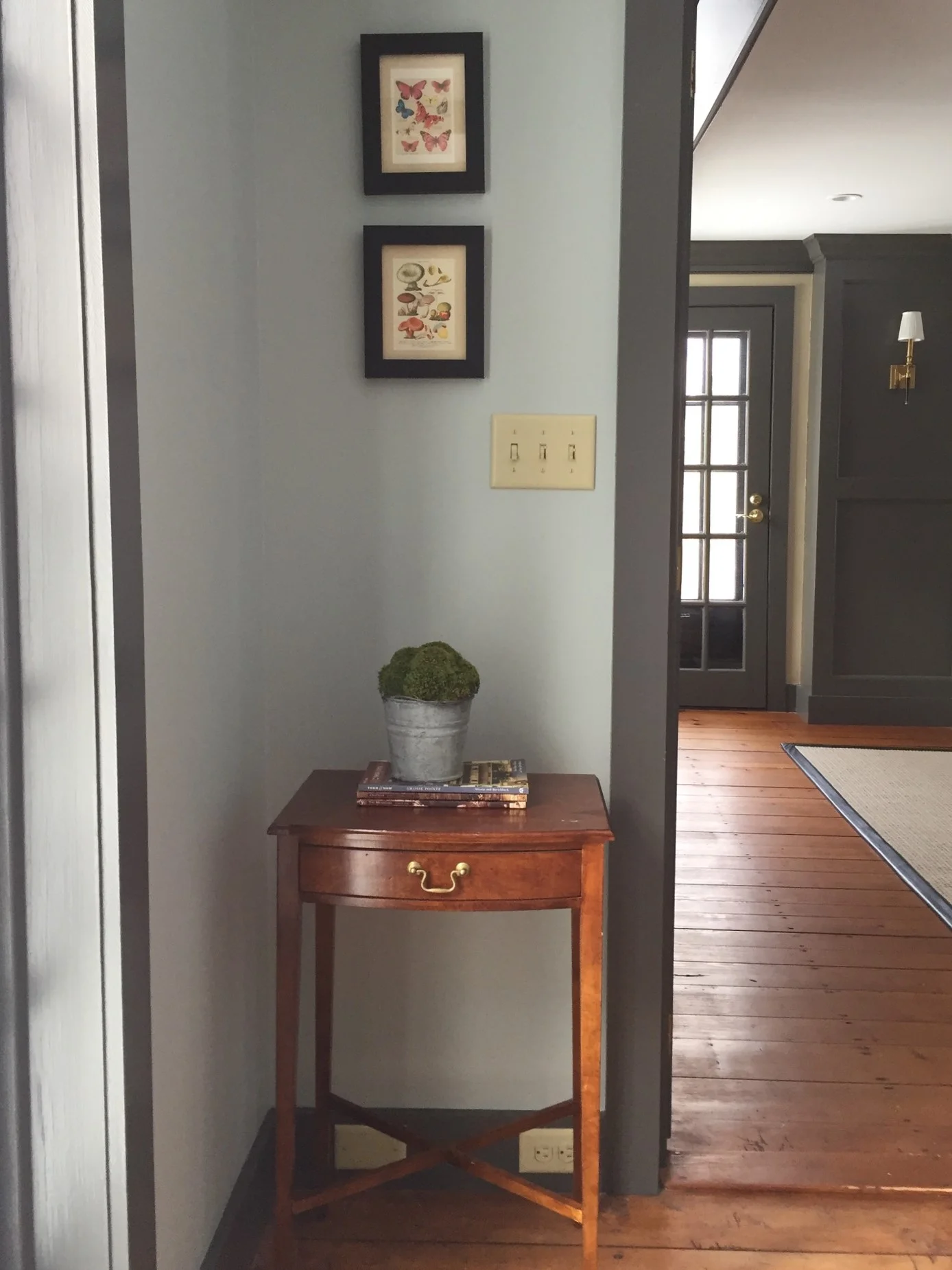 There wasn’t much space here, but we could fit this antique side table next to the door. It’s just enough space to drop the mail or your keys. The trim color (Benjamin Moore’s Kendall Charcoal) is a nice contrast to the walls and helps to define this cozy space.