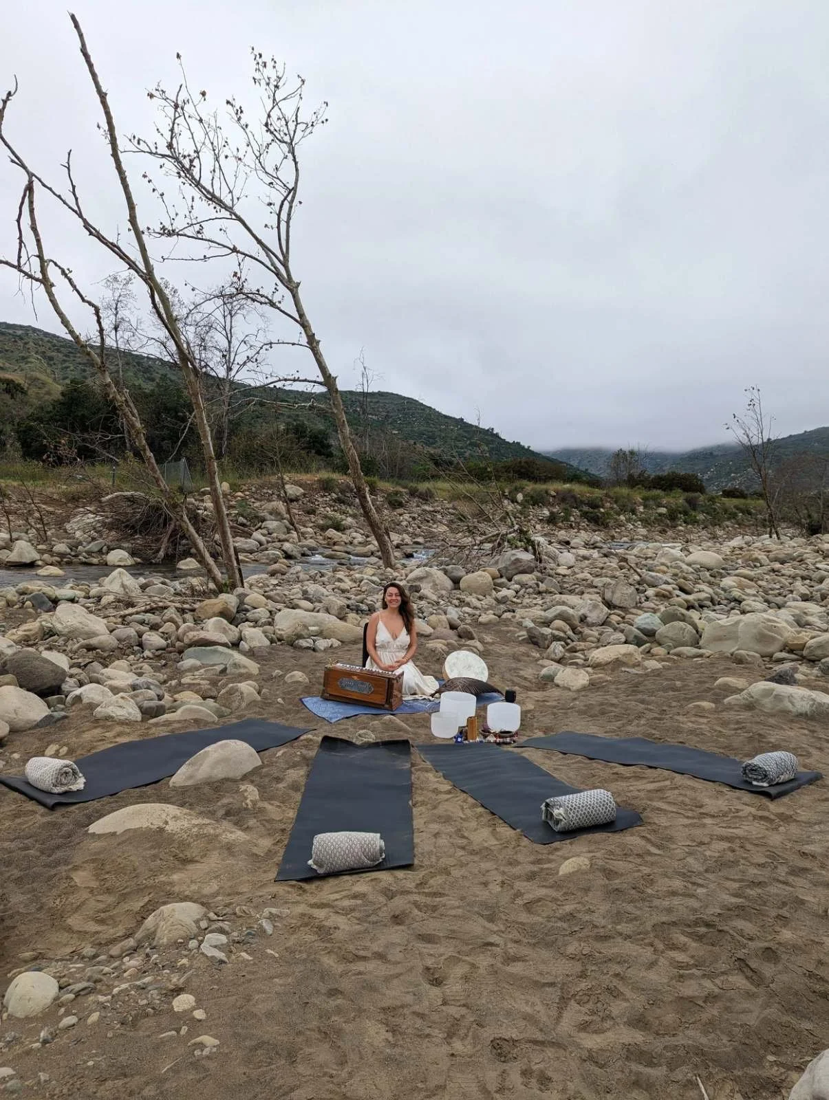 Yoga mats arranged in a circle on a rocky beach
