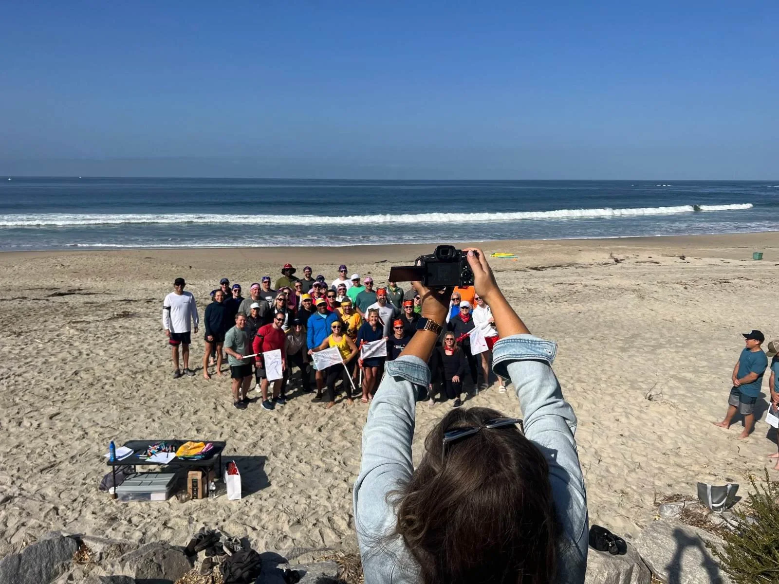 Photographer capturing a large corporate group on the beach