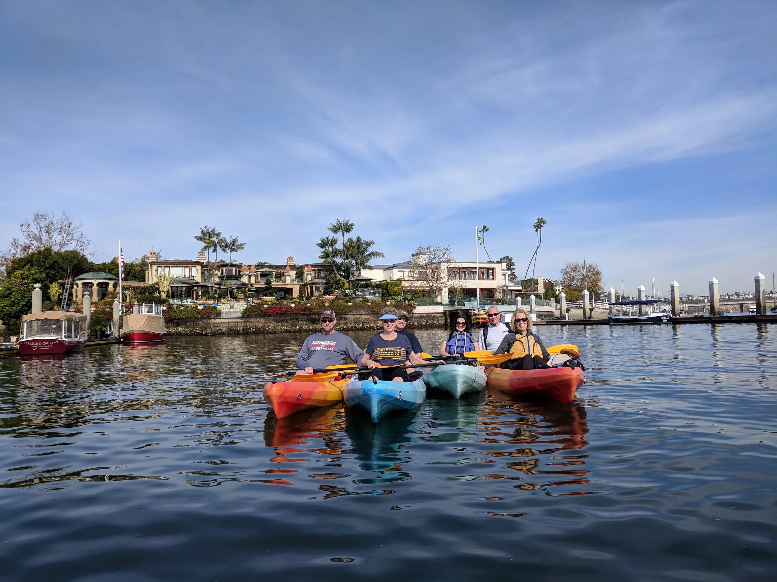 Kayaks rafted together beside waterfront homes in Newport Beach