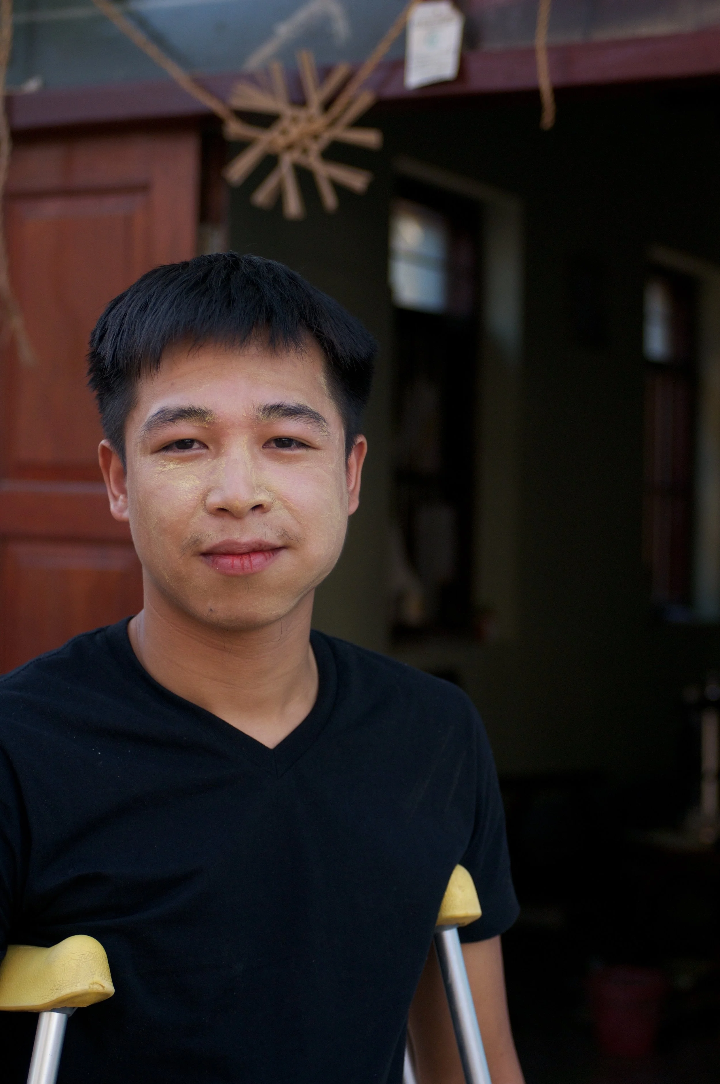 Nan Saai chews on betel, a fragrant nut from the areca palm, as he props himself to stand.