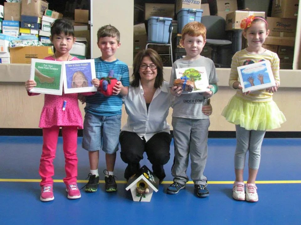 Allison speaking to a class full of kindergarteners along with Persie and her birdhouse.