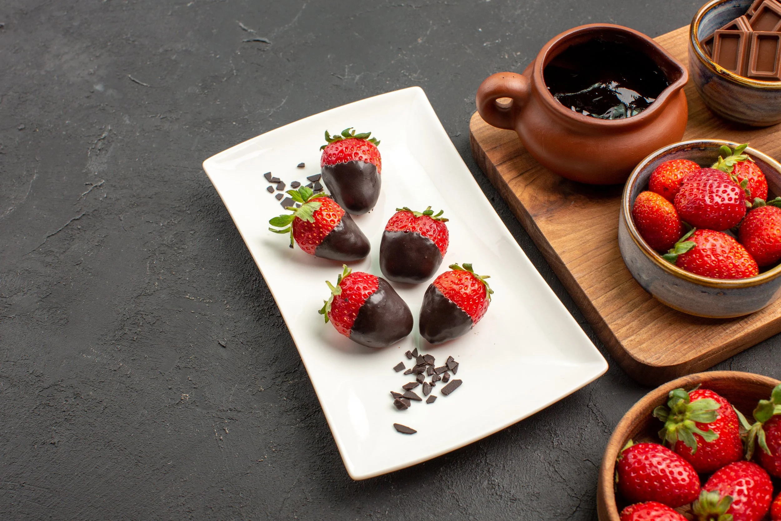 side-close-up-view-chocolate-covered-strawberries-plate-chocolate-covered-strawberries-bars-chocolate-bowl-strawberries-kitchen-board-with-chocolate-cream-strawberries.jpg