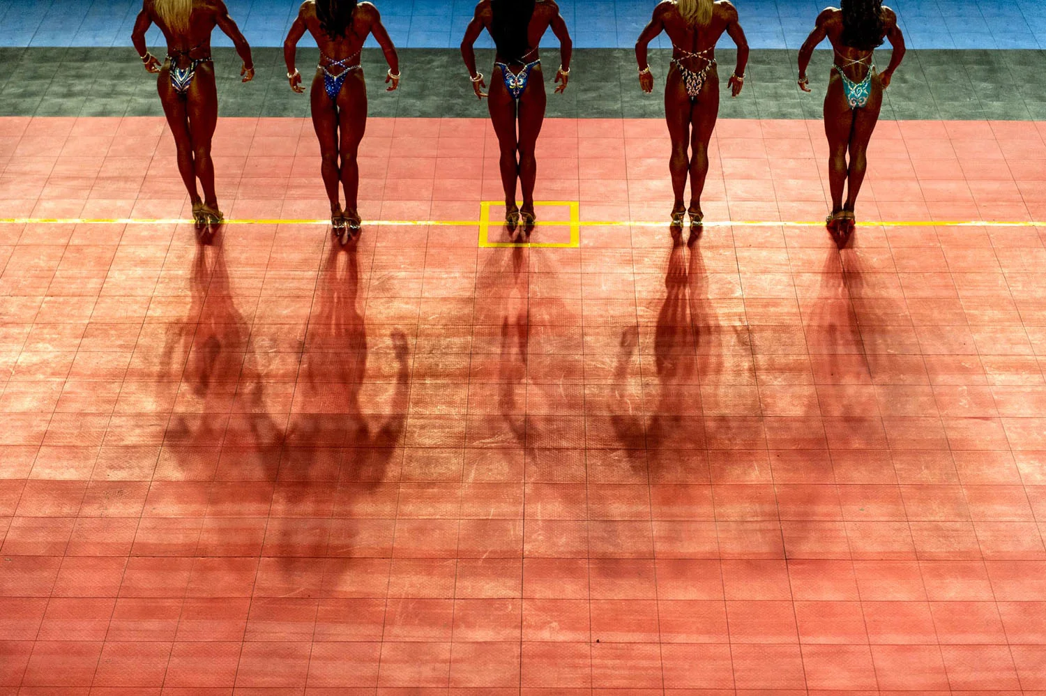 Bodybuilding contestants perform on stage