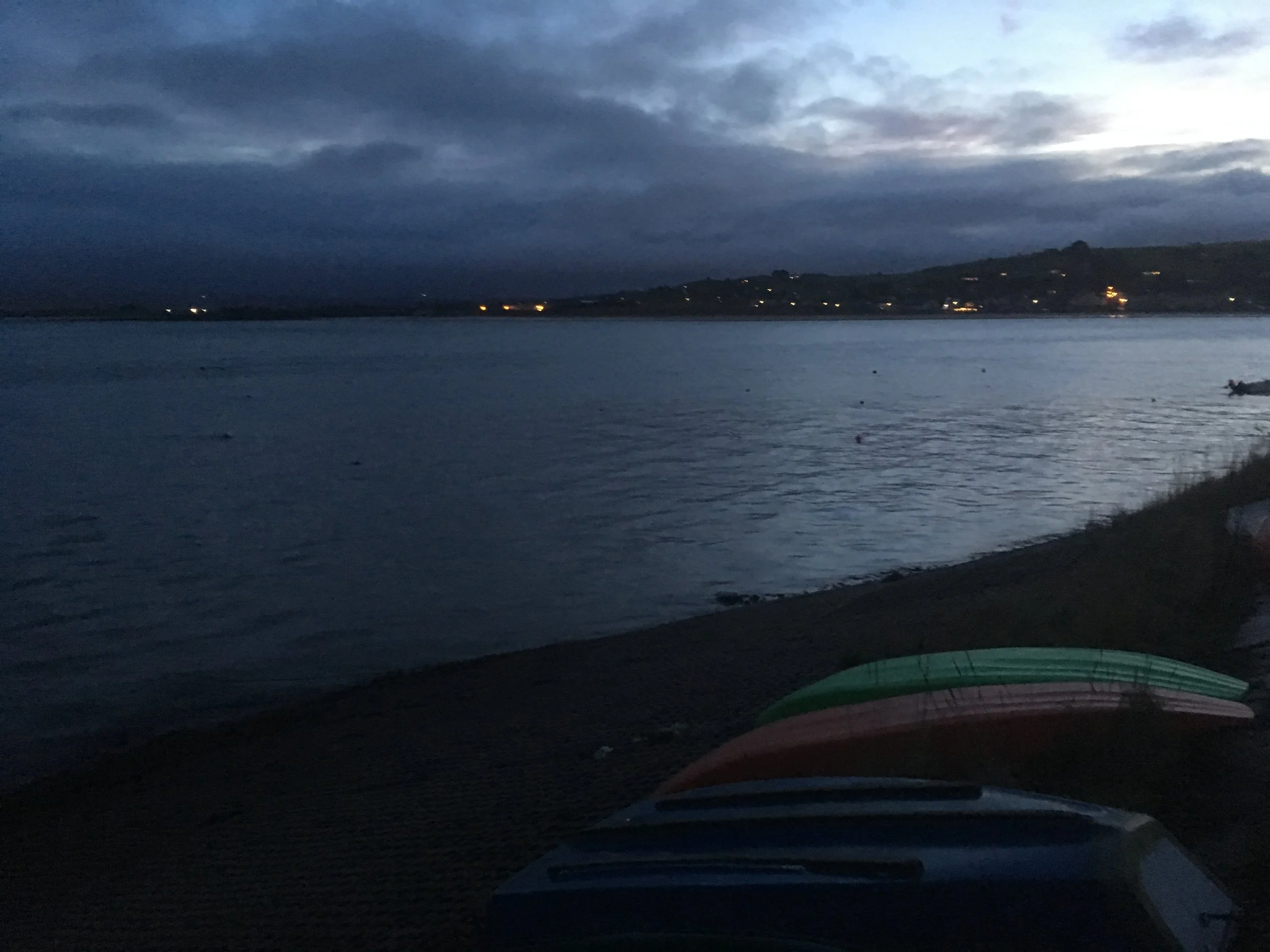 The sun begins to rise across the water