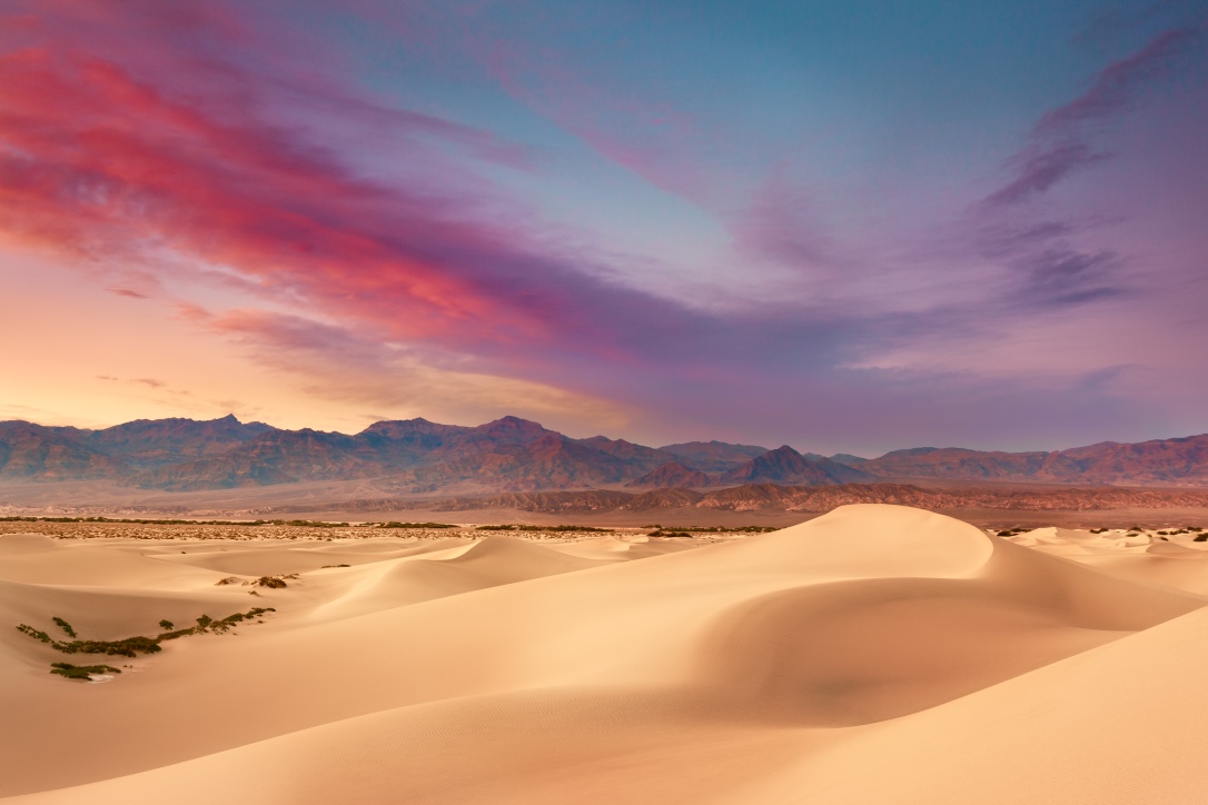 The setting sun sets the sky ablaze during a summer sunset on Mesquite Sand Dunes in Death Valley National Park. - (PHOTO: JARED ROPELATO/SHUTTERSTOCK)