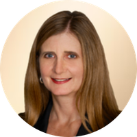 A woman with shoulder-length brown hair, wearing a dark blazer and smiling at the camera.