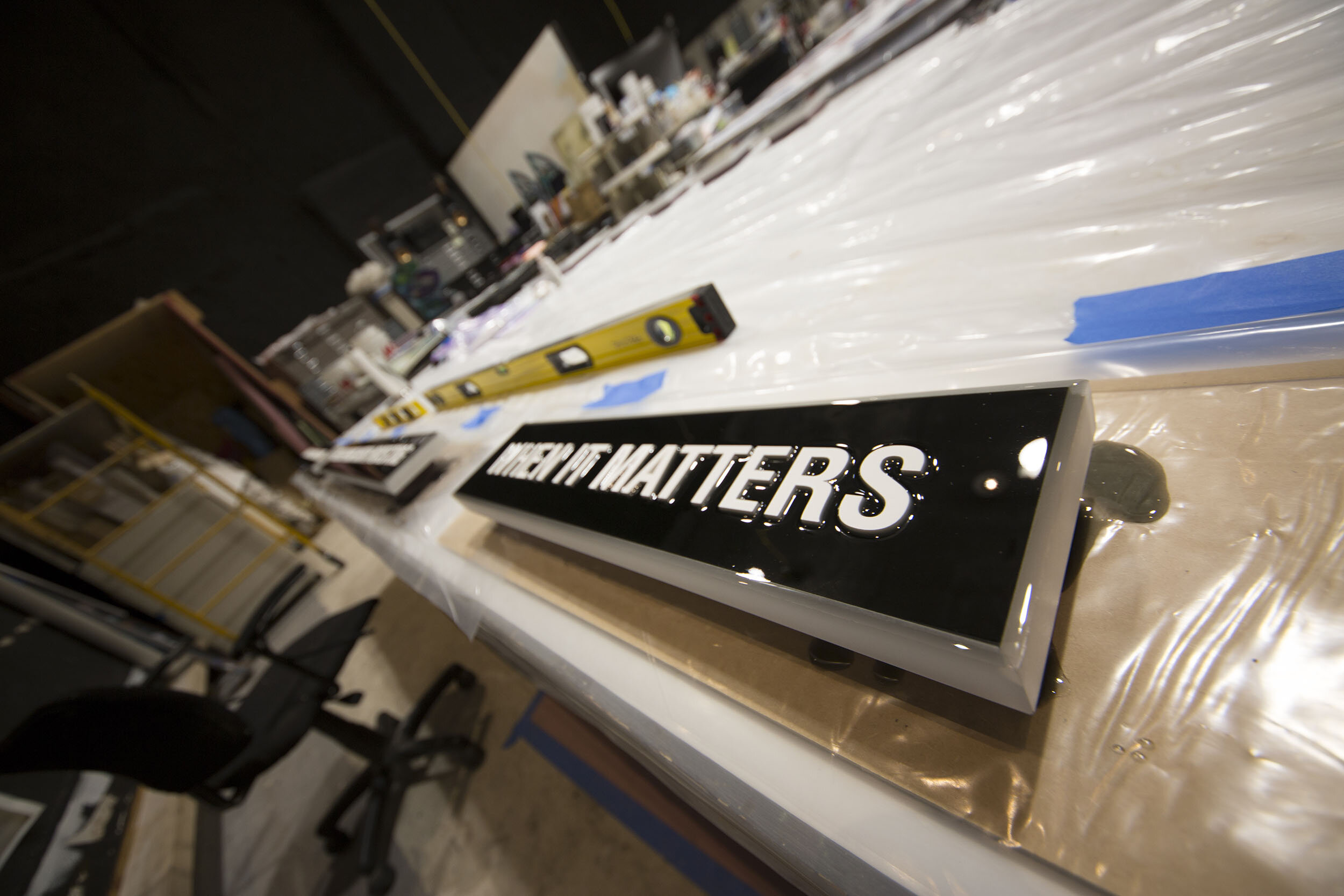 Custom dimensional signage in production at Spolar Studio, featuring layered materials, precision lettering, and a high-gloss finish.