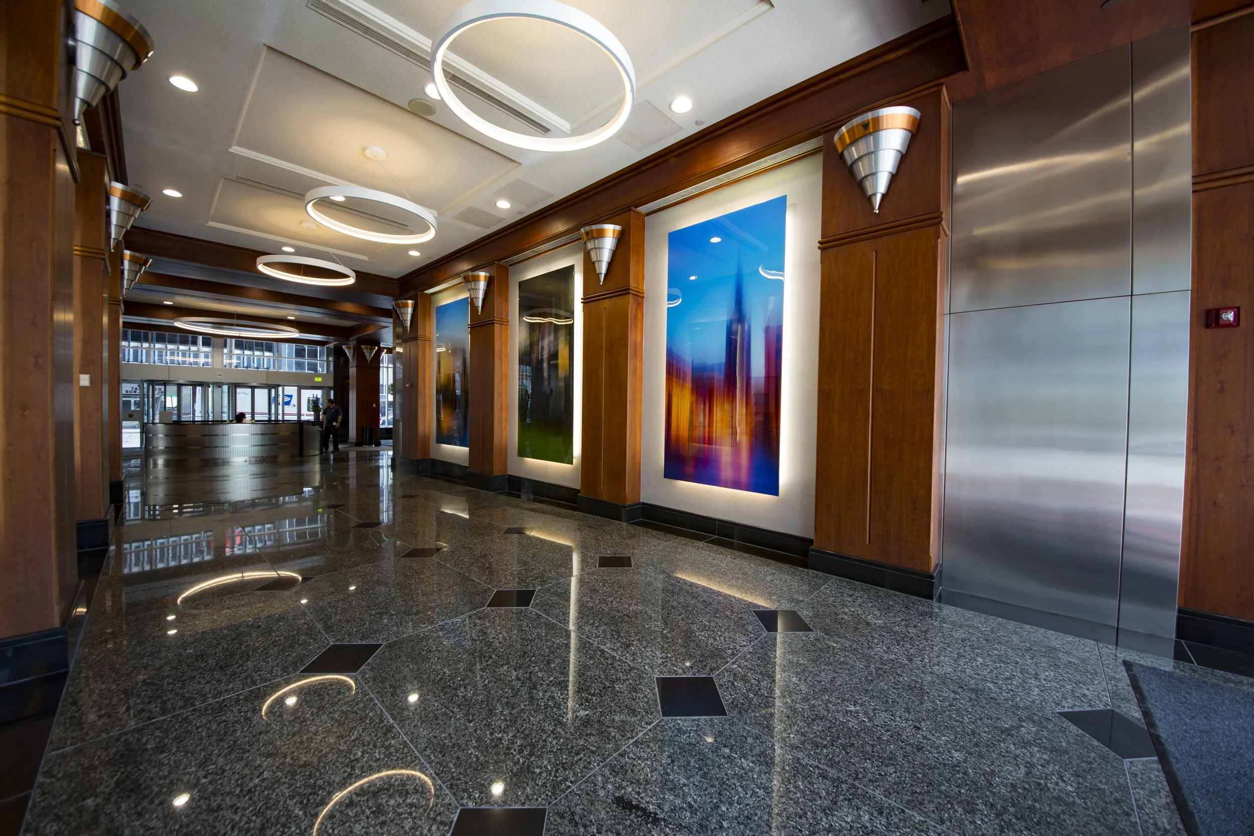 Corporate interior featuring large-scale illuminated artwork, architectural wood detailing, and integrated lighting, demonstrating Spolar Studio's custom environmental design capabilities.