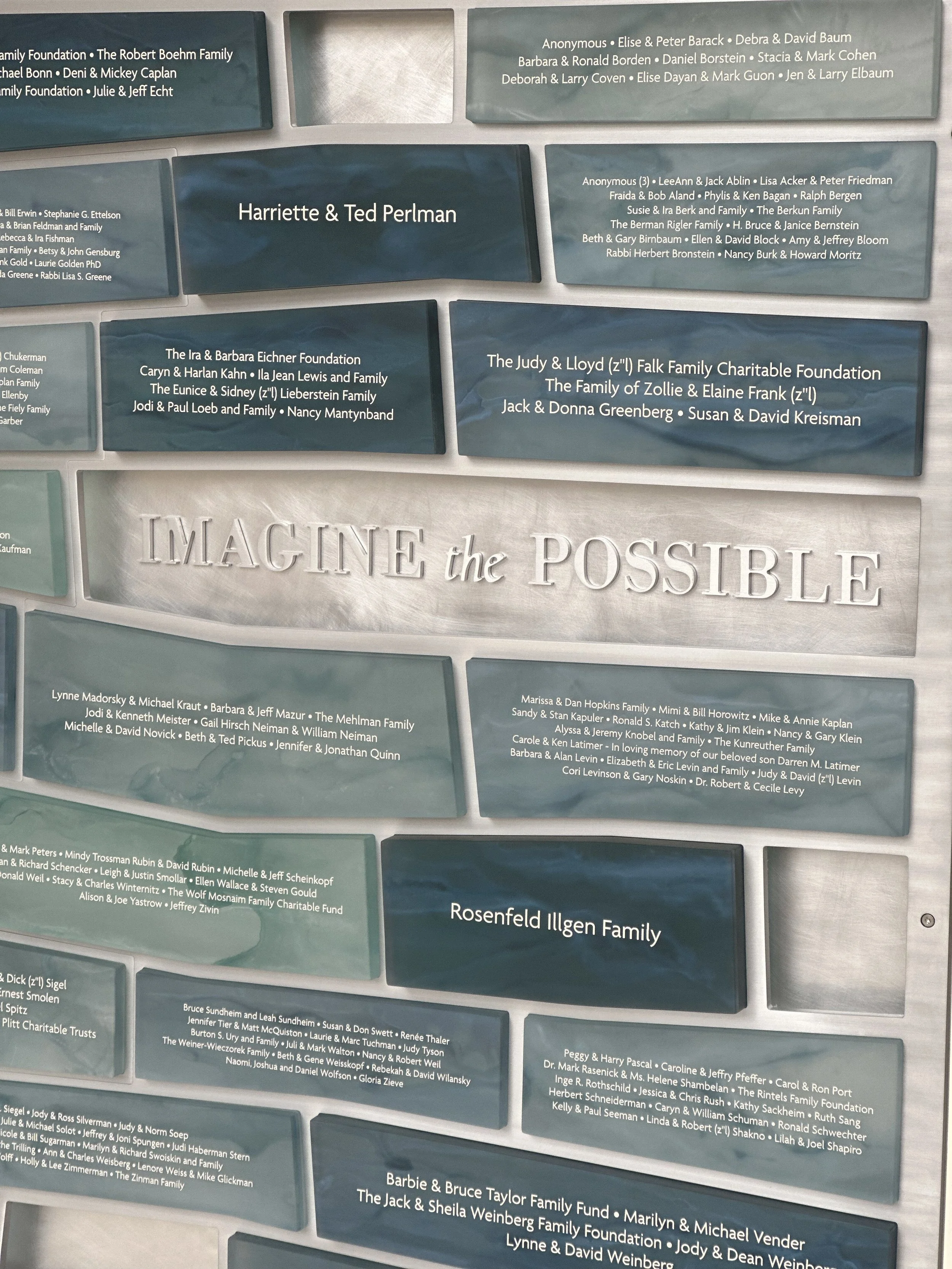 Custom donor recognition wall featuring engraved names, dimensional lettering, and textured architectural panels that celebrate community support.
