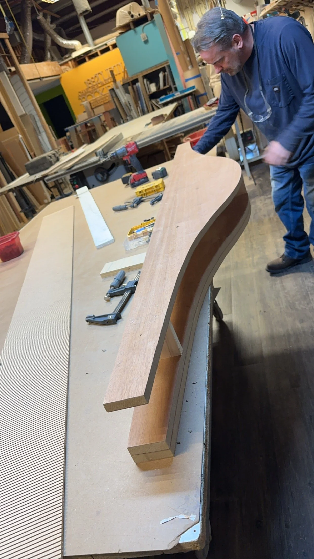 Spolar Studio craftsman building a curved wood component using skilled millwork and hands-on fabrication.