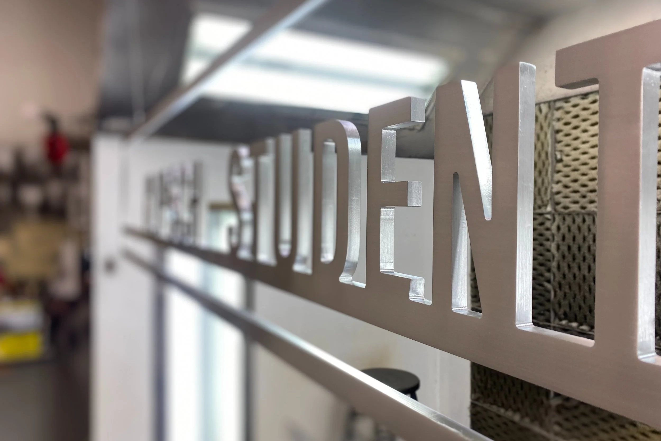 CNC-cut finished metal lettering used to create dimensional architectural signage.
