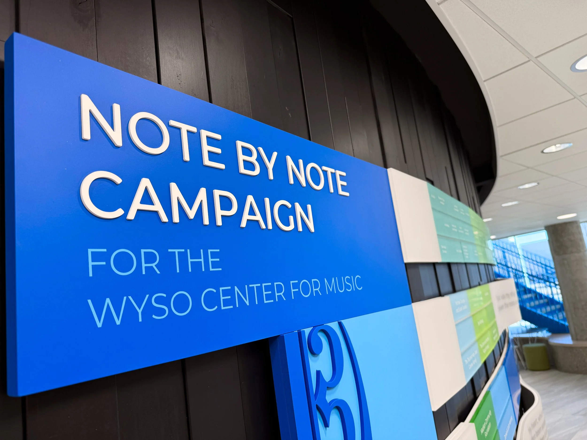 Close-up of the Note by Note campaign donor recognition display with dimensional graphics and modular donor panels.