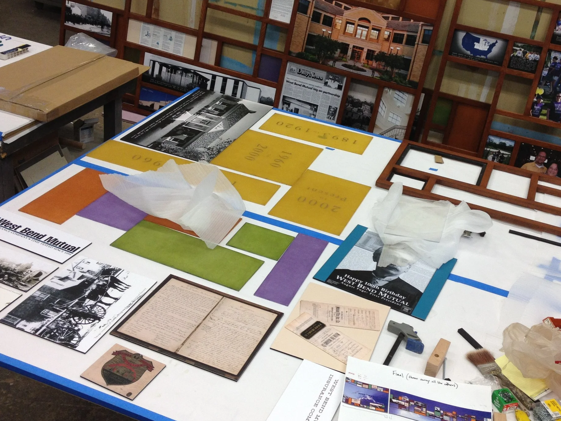 Material samples, graphics, and prototype components arranged during the donor recognition design process.