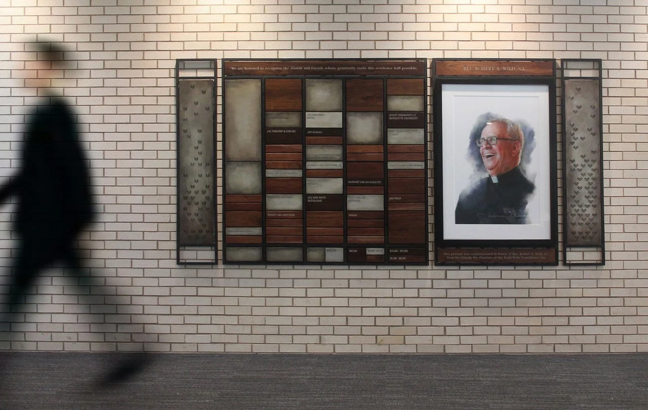Modular donor recognition system with wood and metal donor plaques arranged in a framed grid beside a dedicated recognition portrait.
