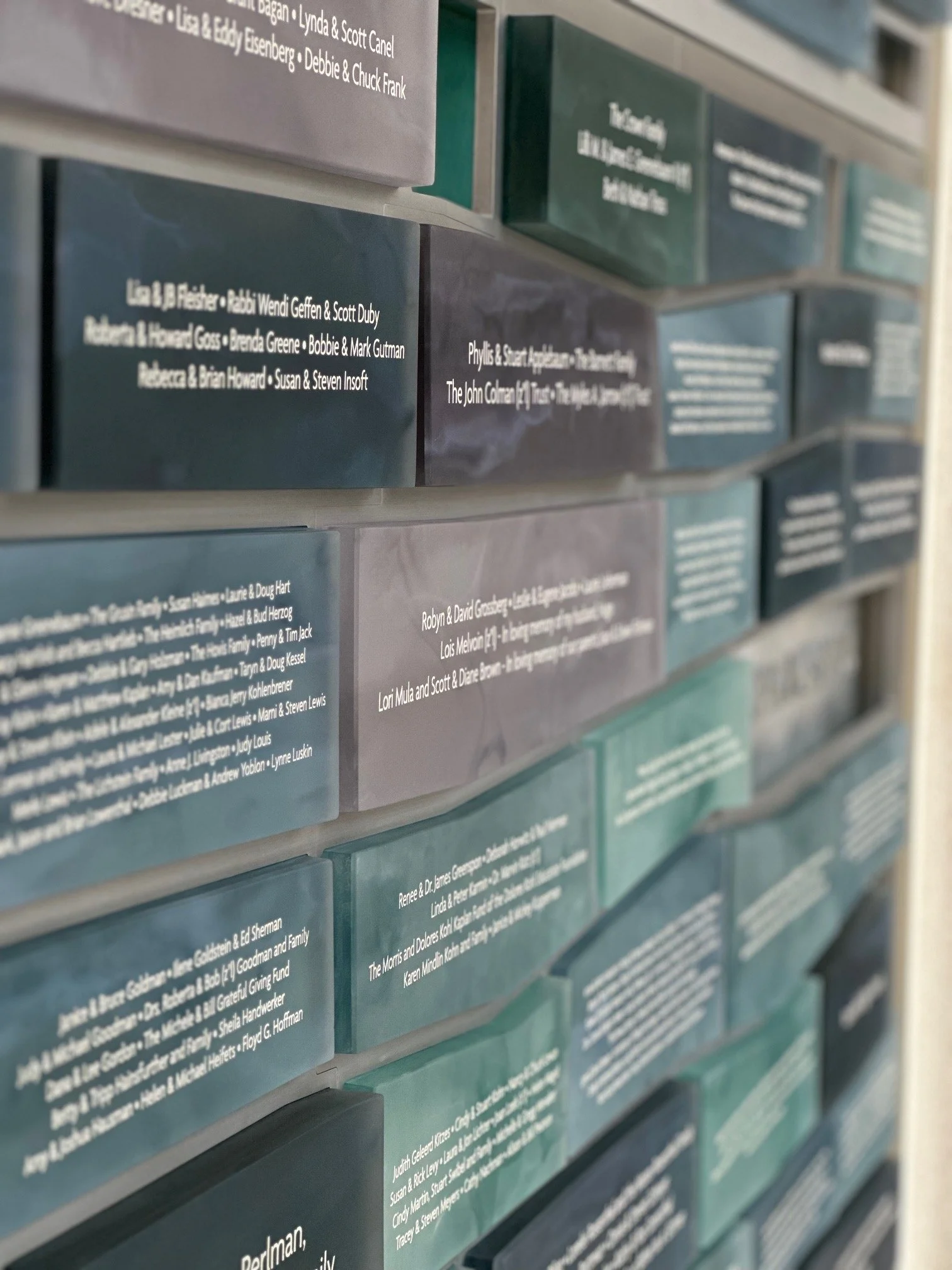 Grid-based modular donor recognition system with individual translucent donor plaques arranged in a structured wall display.