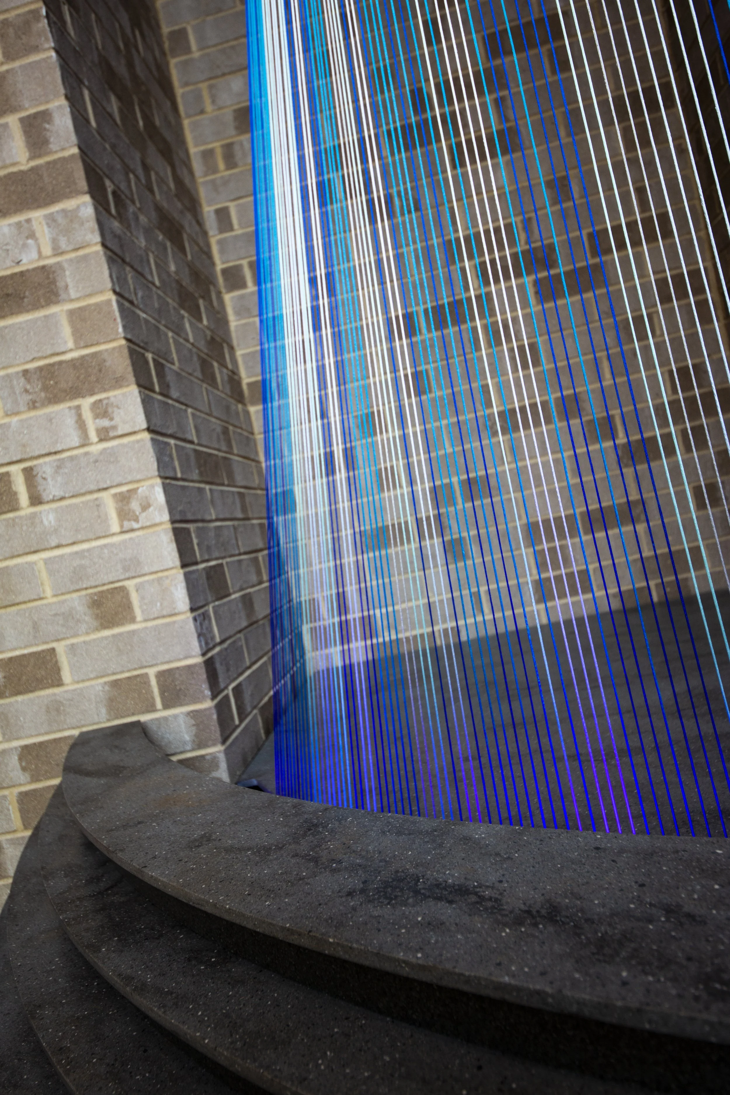 Custom illuminated string sculpture combining tensioned lines, dimensional materials, and integrated lighting.