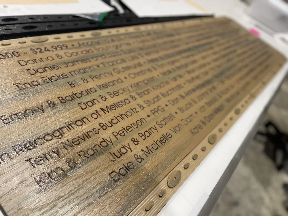 Close-up of engraved donor names with contrasting HDPE lettering inset into the Adventure Africa recognition display.