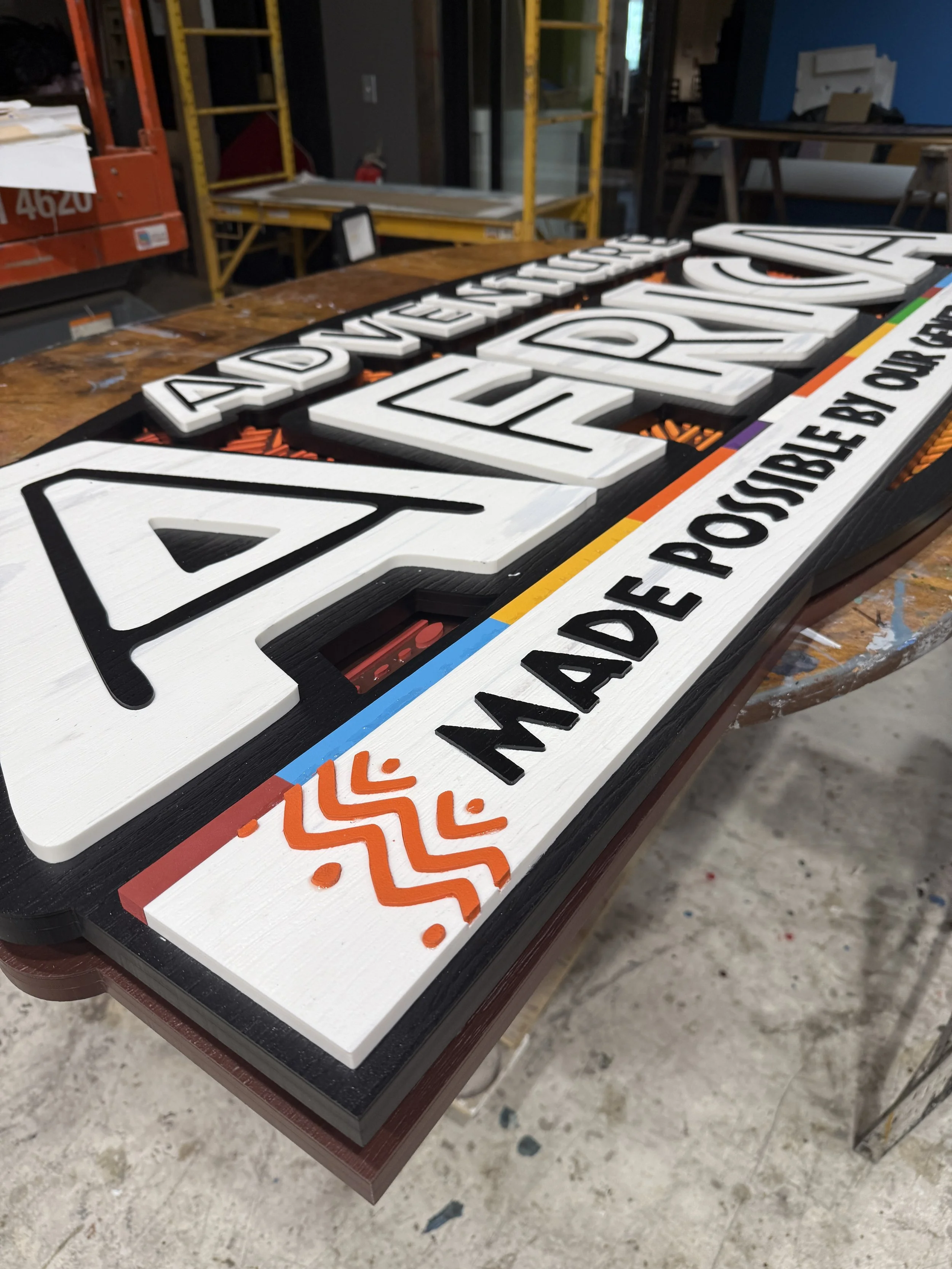 Layered HDPE signage components showing the color palette and dimensional fabrication used in the Adventure Africa installation.