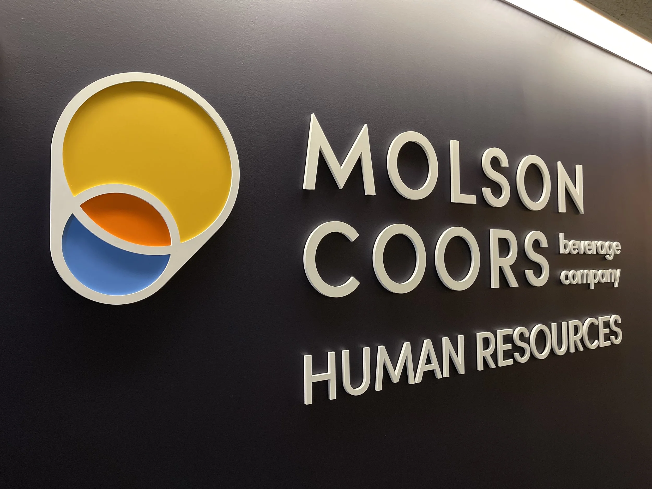 Branded workplace environment featuring custom graphics, recognition, and architectural elements.