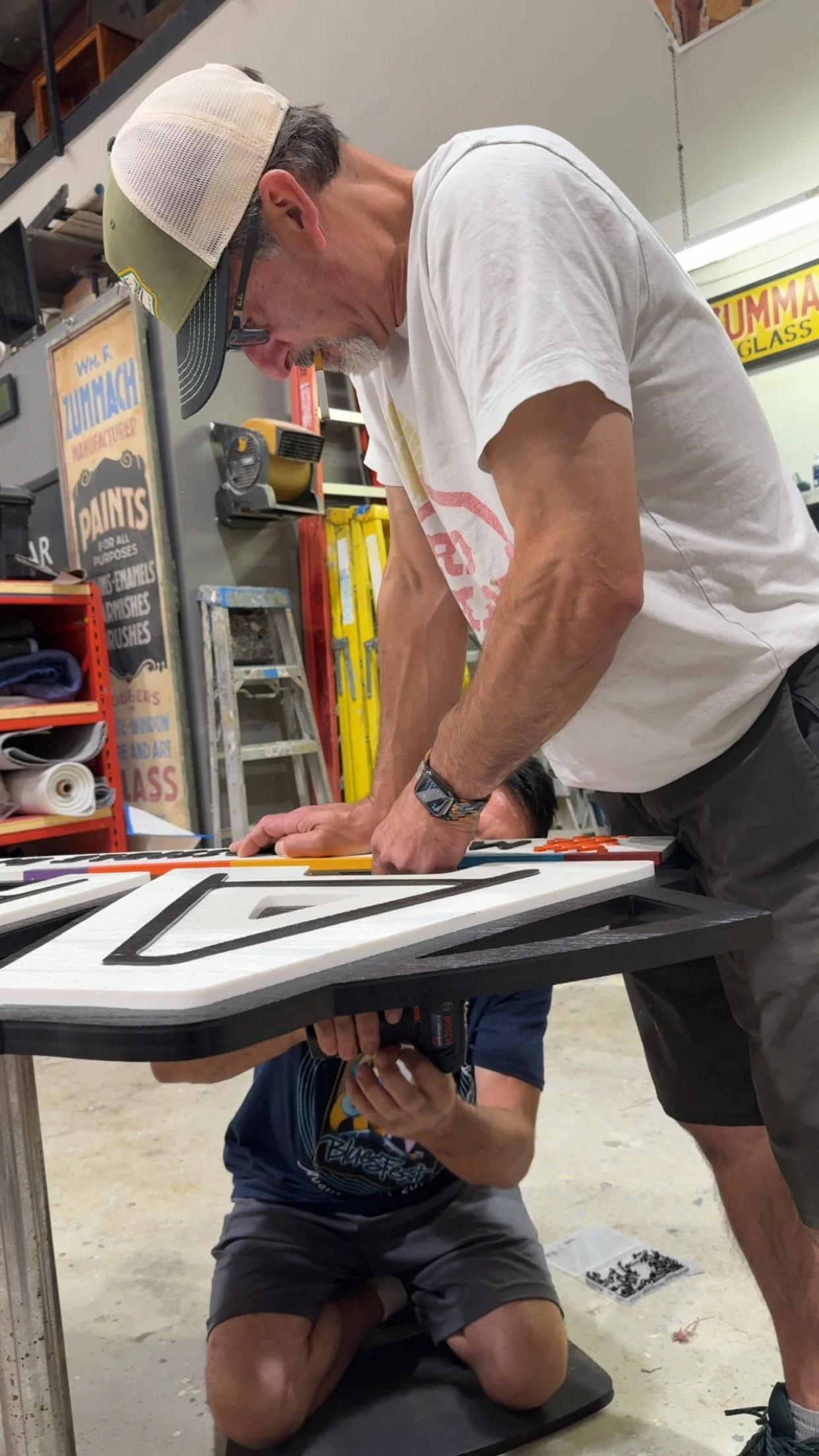 Spolar Studio fabricators working together to assemble and fit custom dimensional components in the workshop, demonstrating hands-on fabrication expertise.