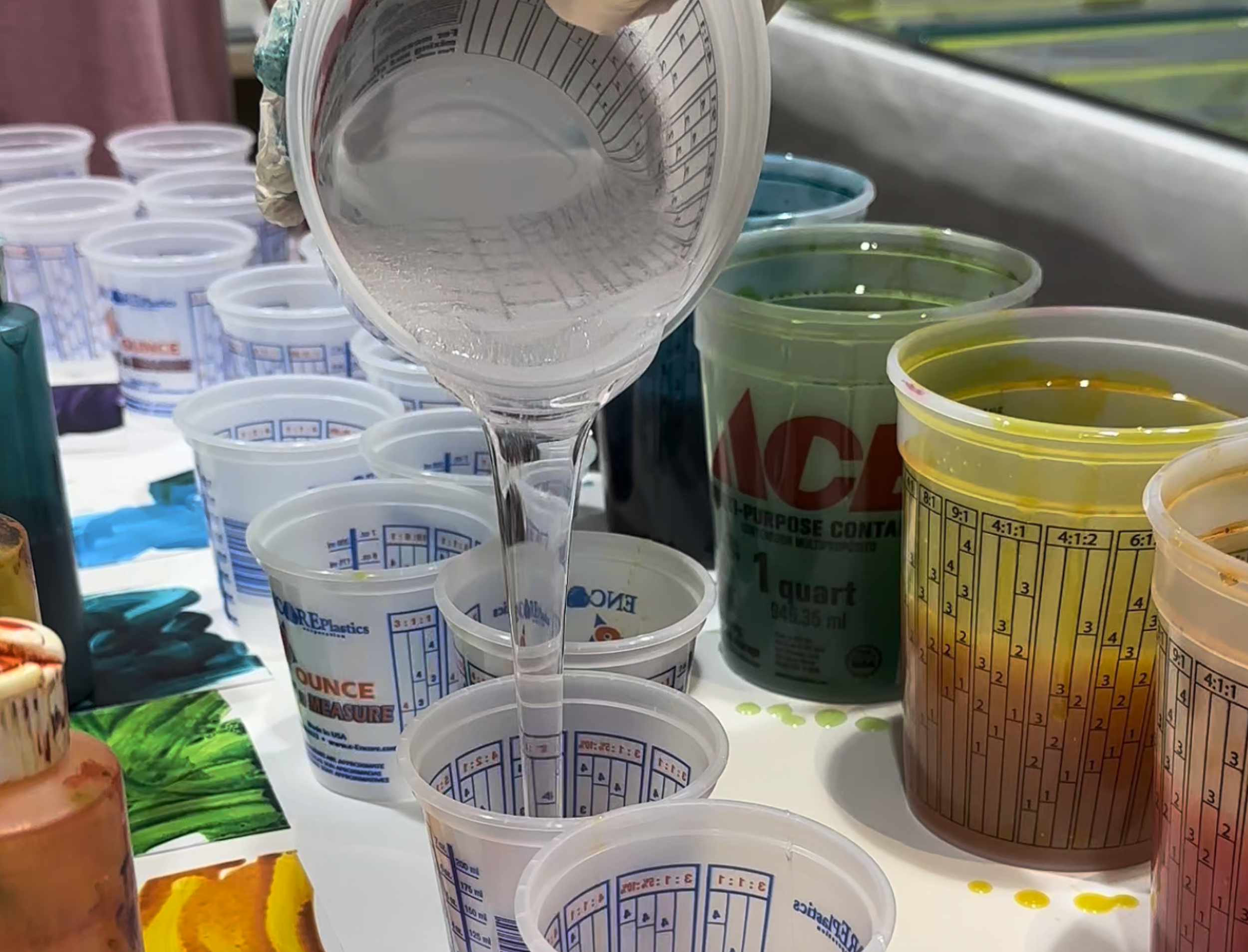 Resin being poured and mixed during a custom fabrication process.