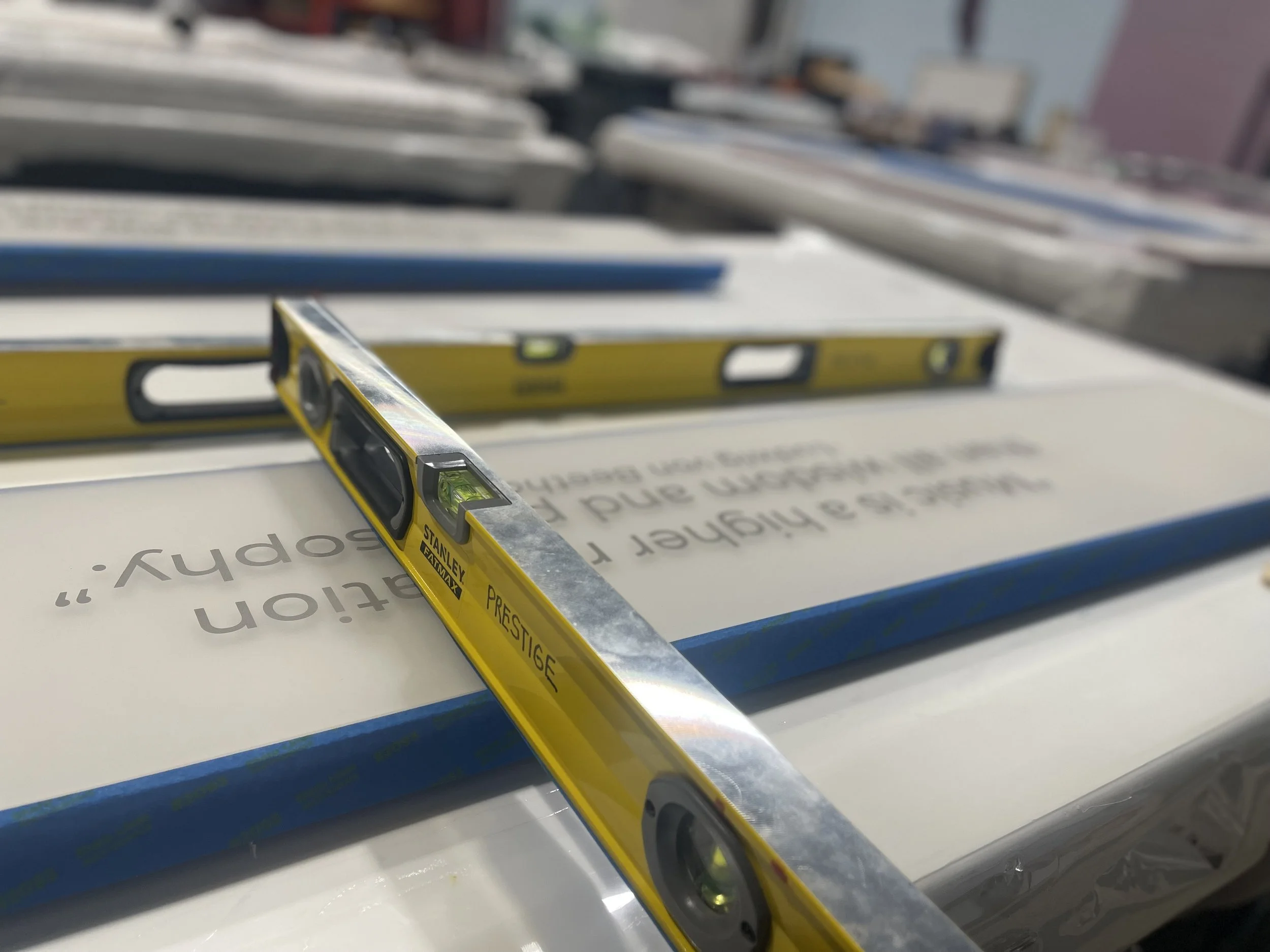 Fabricated donor recognition panel being checked with a level during production and installation preparation.