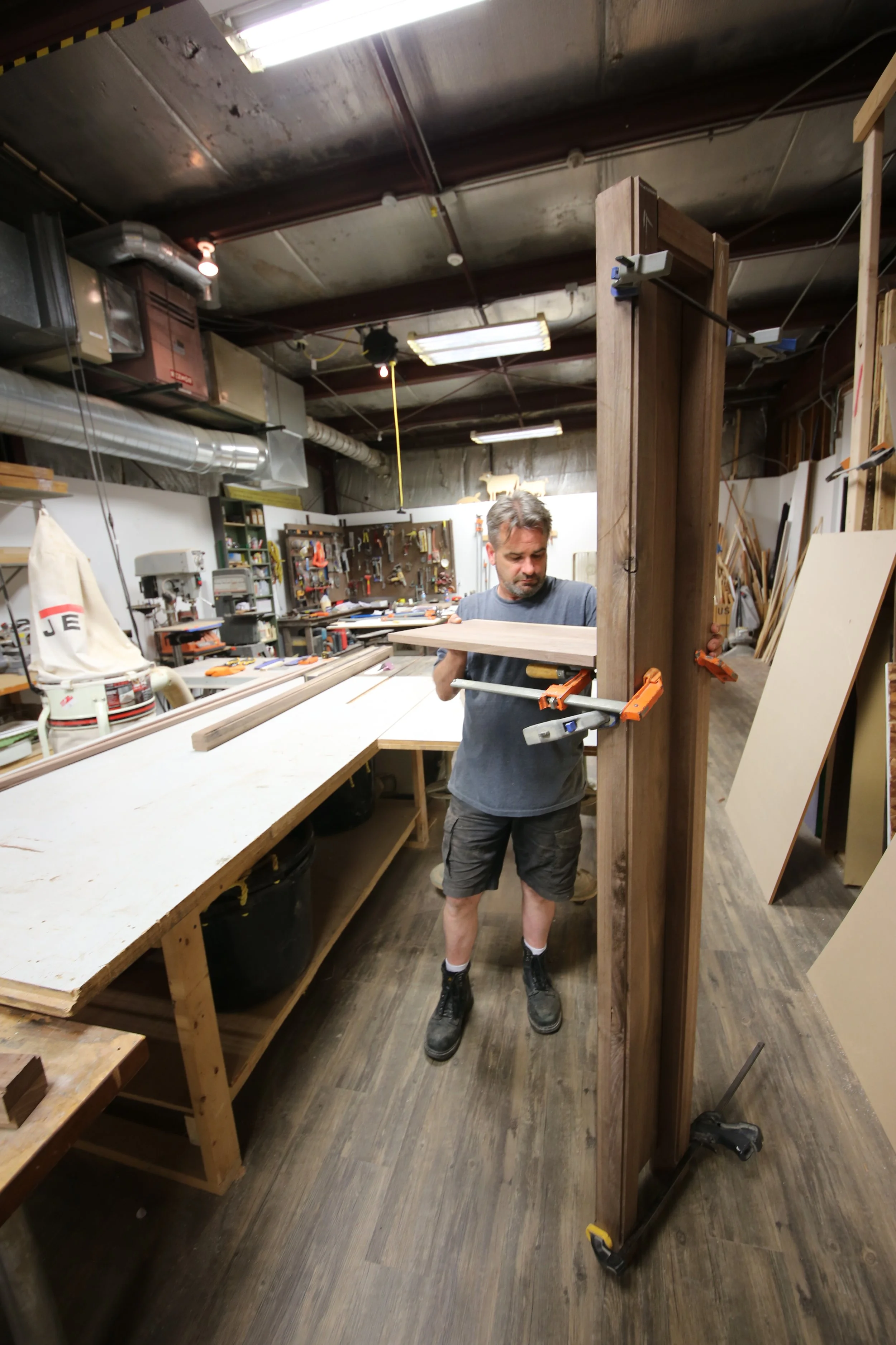 Spolar Studio craftsman fitting and assembling a large custom wood feature in the fabrication shop.