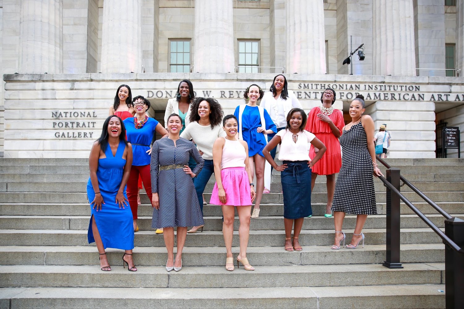  12 Black women standing up laughing on steps outside the National Portrait Gallery in Washington, D.C.  Photos:  Milli Mike / Millgrimage  