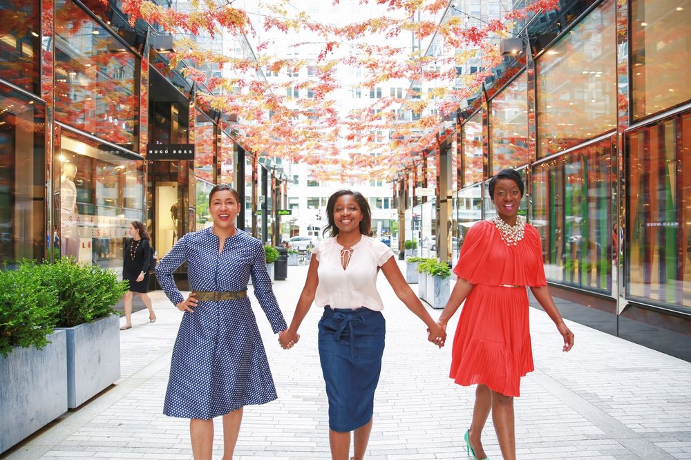 3 Black women holding hands facing the camera in City Center, Washington, D.C. Photos: Milli Mike / Millgrimage