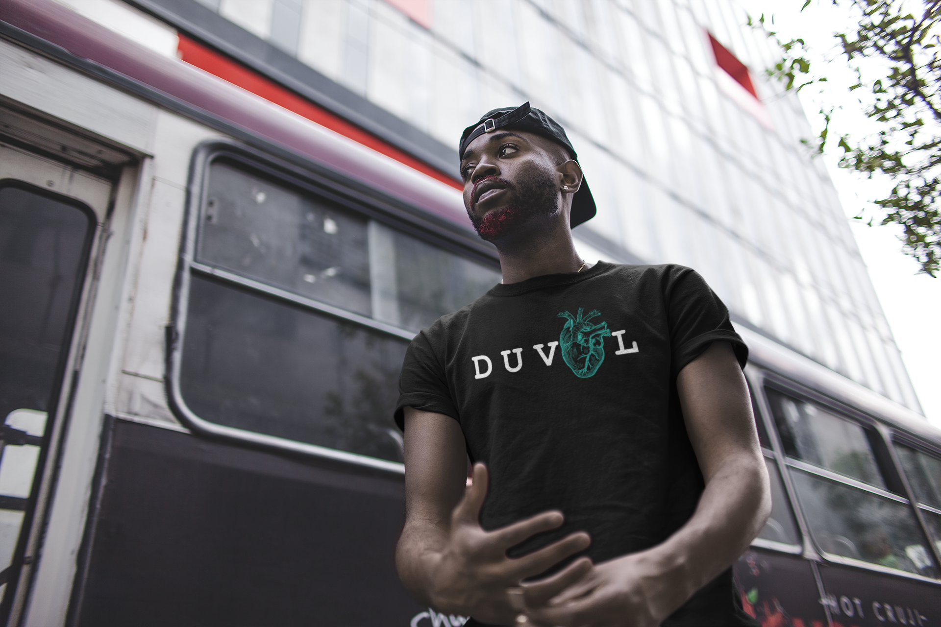 mockup-of-a-man-wearing-a-tee-in-front-of-a-city-bus-21680.png
