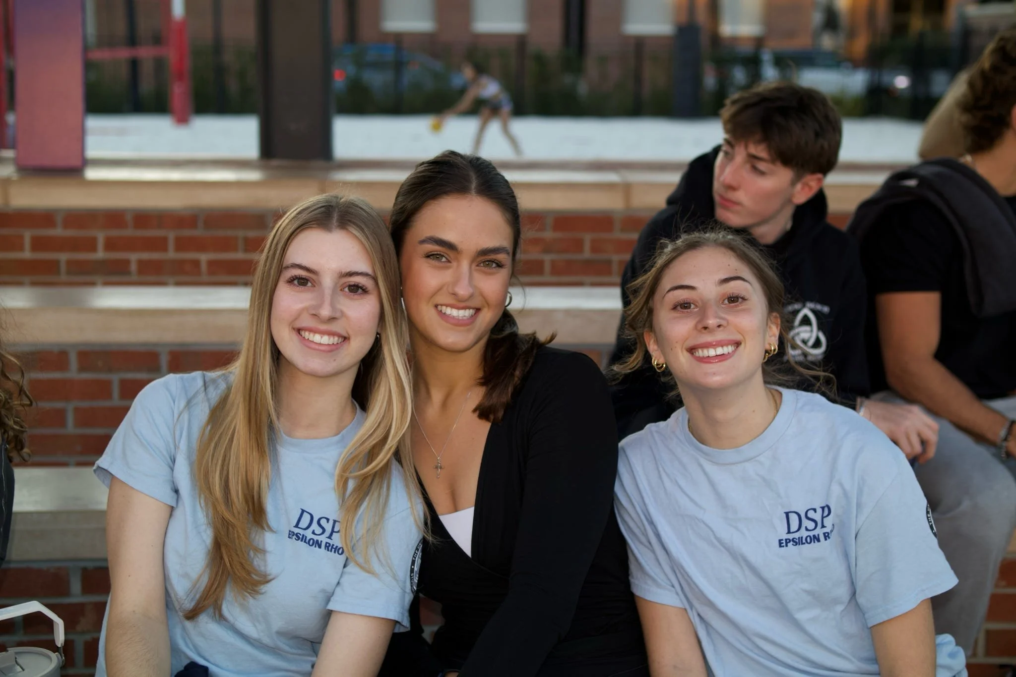 Three brothers smiling to the camera, two of them wearing DSP - Epsilon Rho T-shirts.
