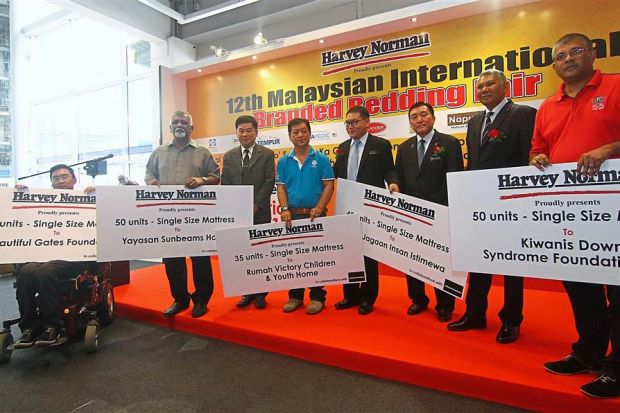Harvey Norman Bedding Department general manager Eddy Ng (fourth from right), Ong (third from right) and Aruldoss (second from right) with representatives from the welfare homes at the handover ceremony.