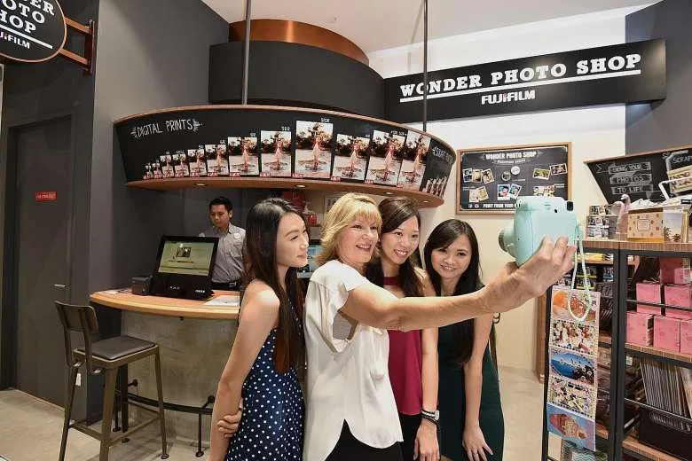 Harvey Norman chief executive Katie Page (second from left) posing for a wefie on Thursday with staff (from left) Gina Chan, Samantha Wong and Fiona Low at Singapore's first Fujifilm Wonder Photo Shop in the new Harvey Norman store in Millenia Walk.PHOTO: DIOS VINCOY JR FOR THE STRAITS TIMES