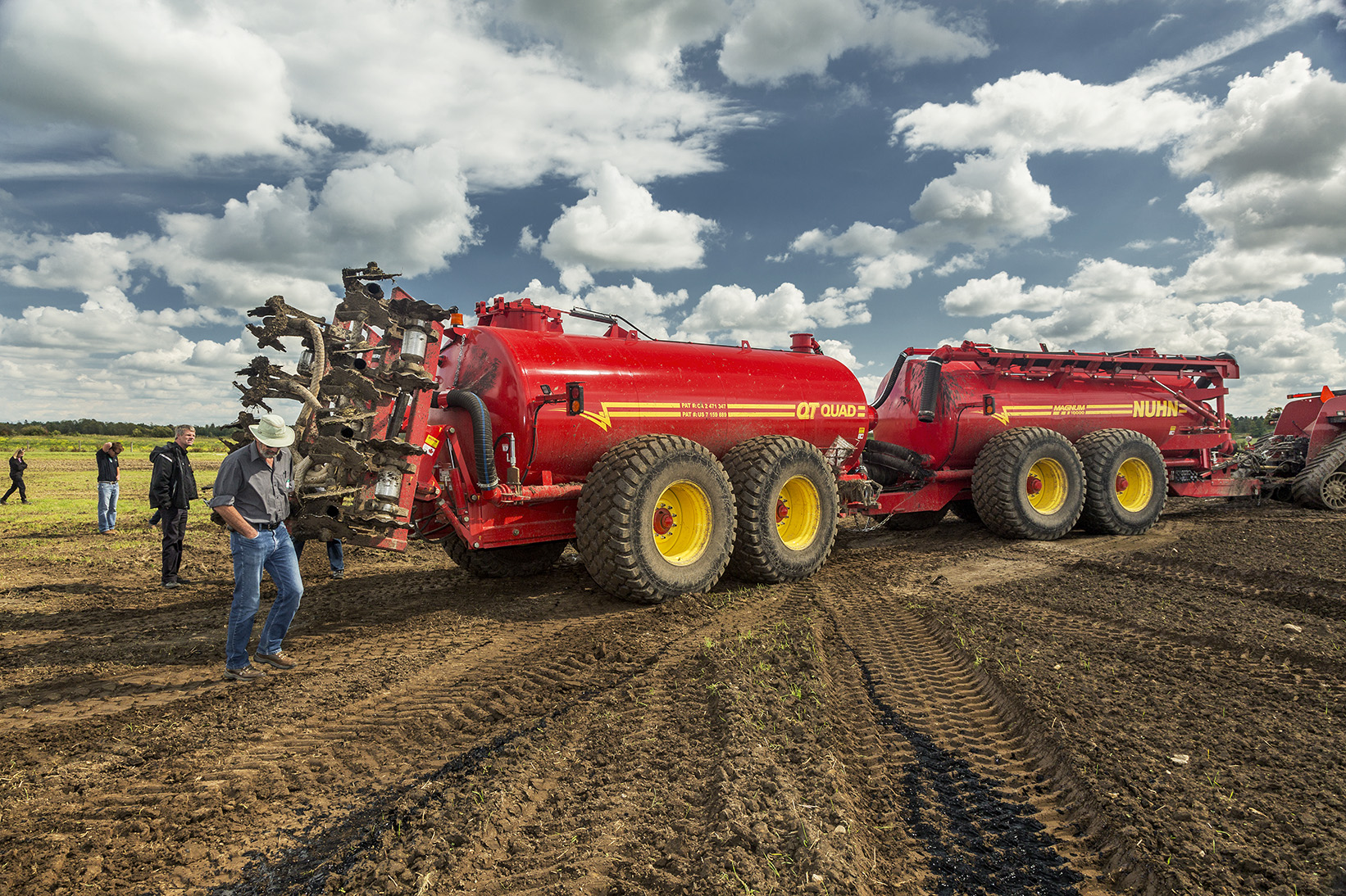 The field injector moves onto the field, its injection tines raised (left, behind person).
