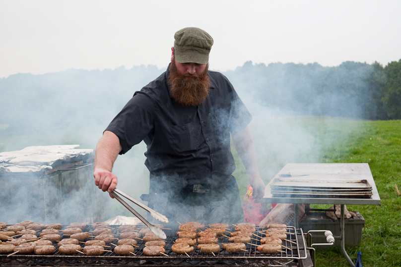 The food is prepared in a remote kitchen. Here they grill lamb sausage on the farm where the sheep were raised.