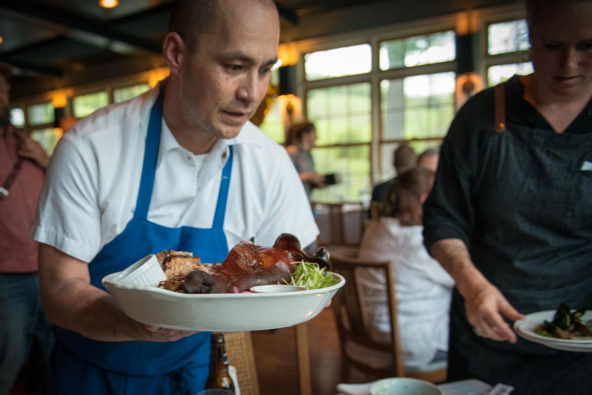 Chef Sumi brings the pig head to the table.