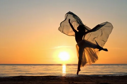 Open hand under sunset with sun in background