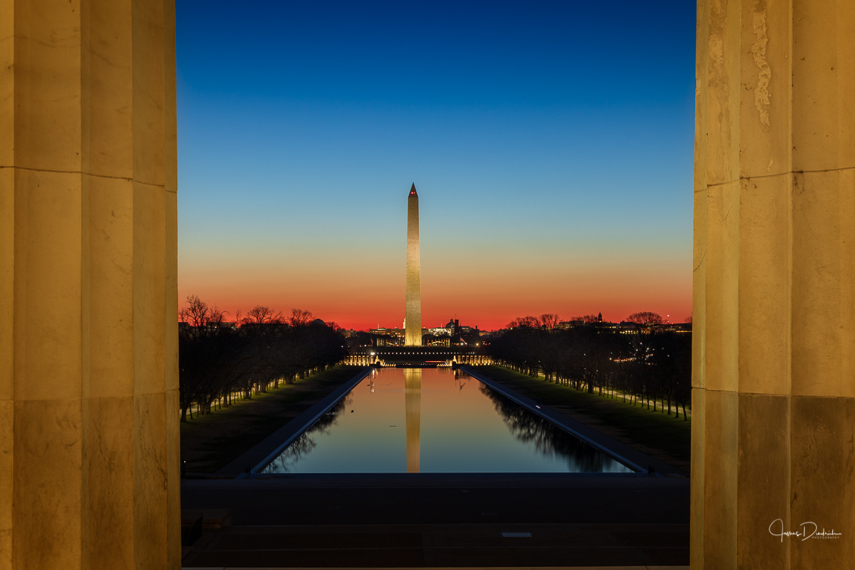 The scene is set with clear skies as I look out onto the National Mall from between the columns at the Lincoln Memorial. The sun is beginning to rise and it is looking good.