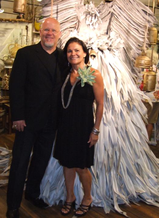 Susan and Doug Williams in Kalalou's Atlanta showroom. The one-of-a-kind angel, designed and assembled in house, is made of latex flowers (as is Susan's "corsage"), one of the company's most successful introductions this year.