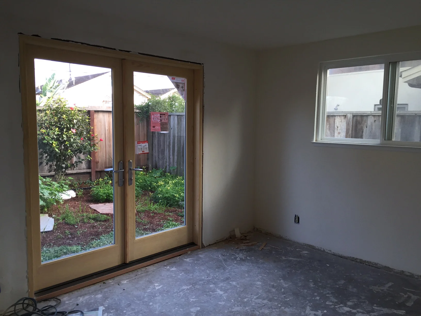 New Milgard french doors installed in the downstairs bedroom and the carpet ripped out.