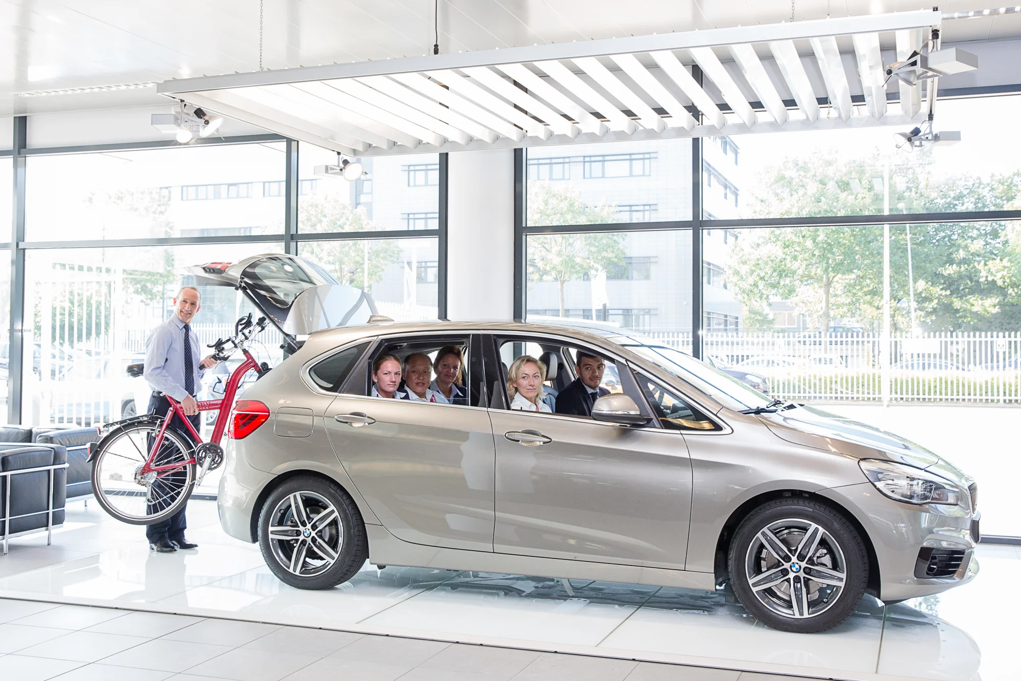 Verschillende BMW medewerkers en cafetaria personeel in de BMW 2 Active Tourer bij de BMW-importeur in Rijswijk 