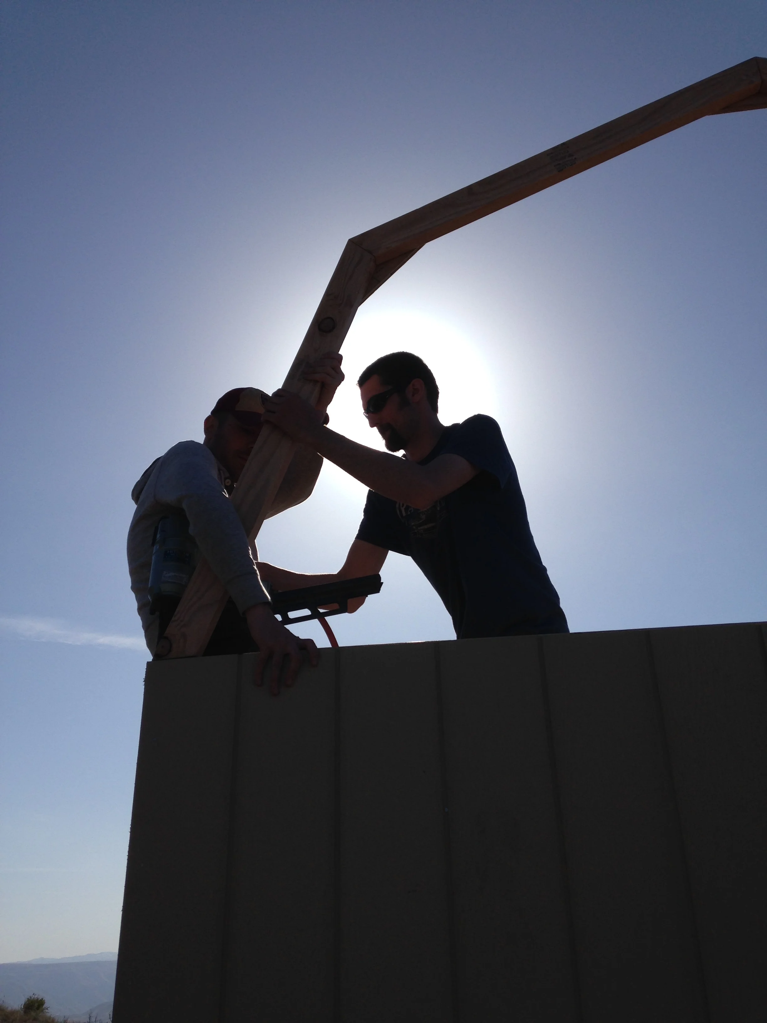 Justin perched himself on the corner to hold the trusses in place while Alex toenailed them in. Alex took a moment to pose awkwardly with his framing hammer.