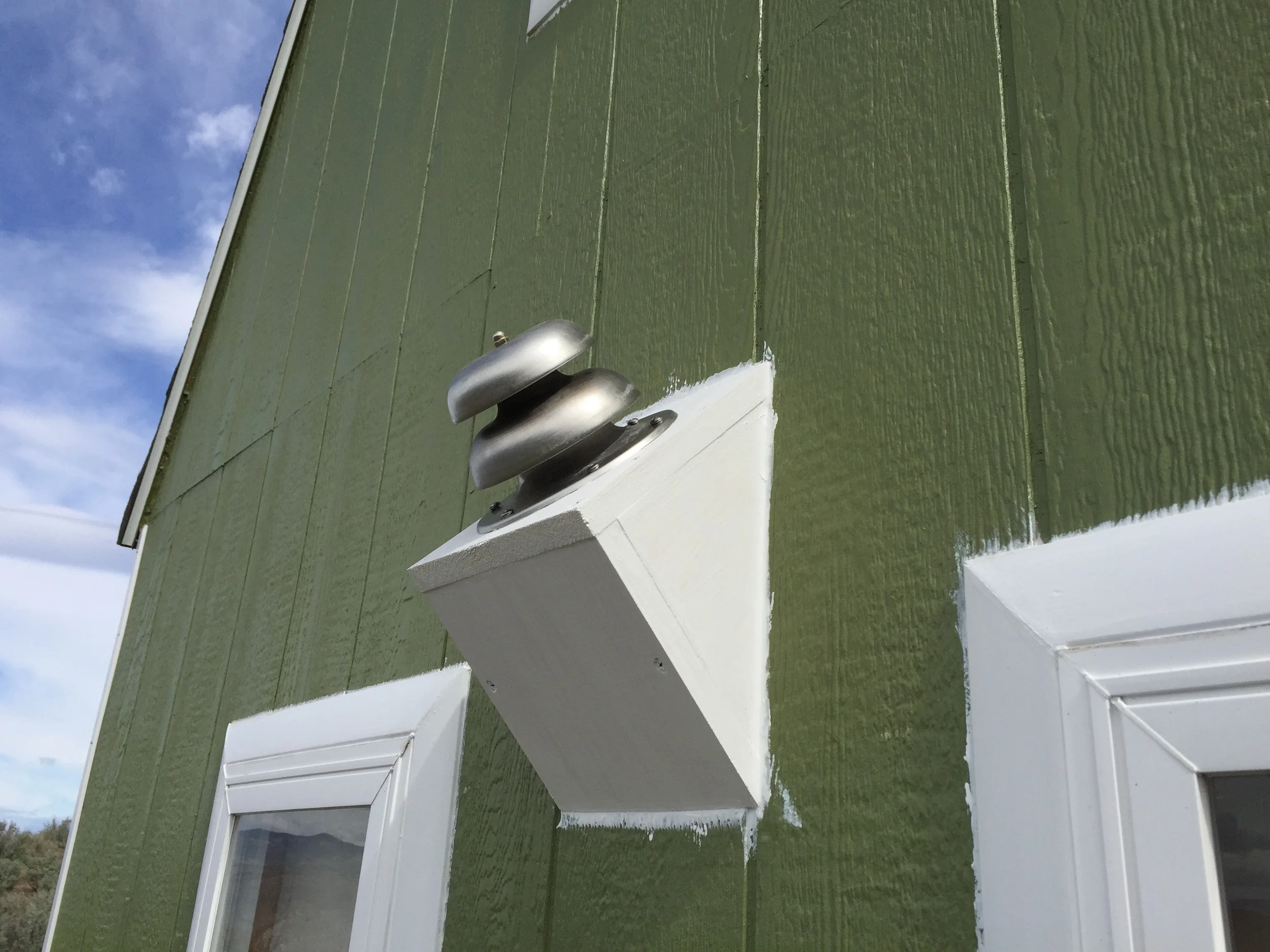 The back side of the cabin now houses the fireplace flue—a dual intake/exhaust pipe with a bell cap.