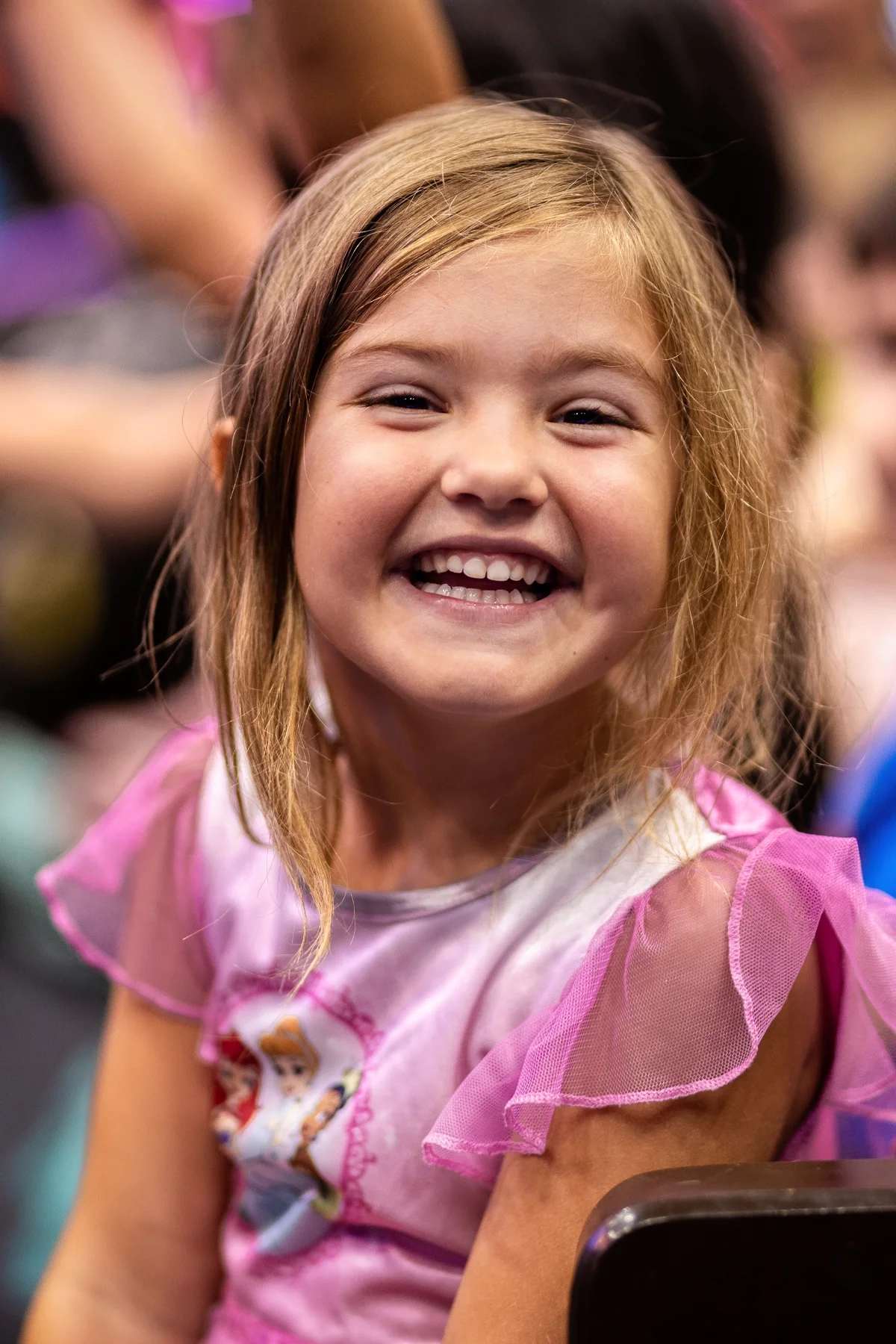 A preschooler smiling during an indoor activity at Strauss ECE