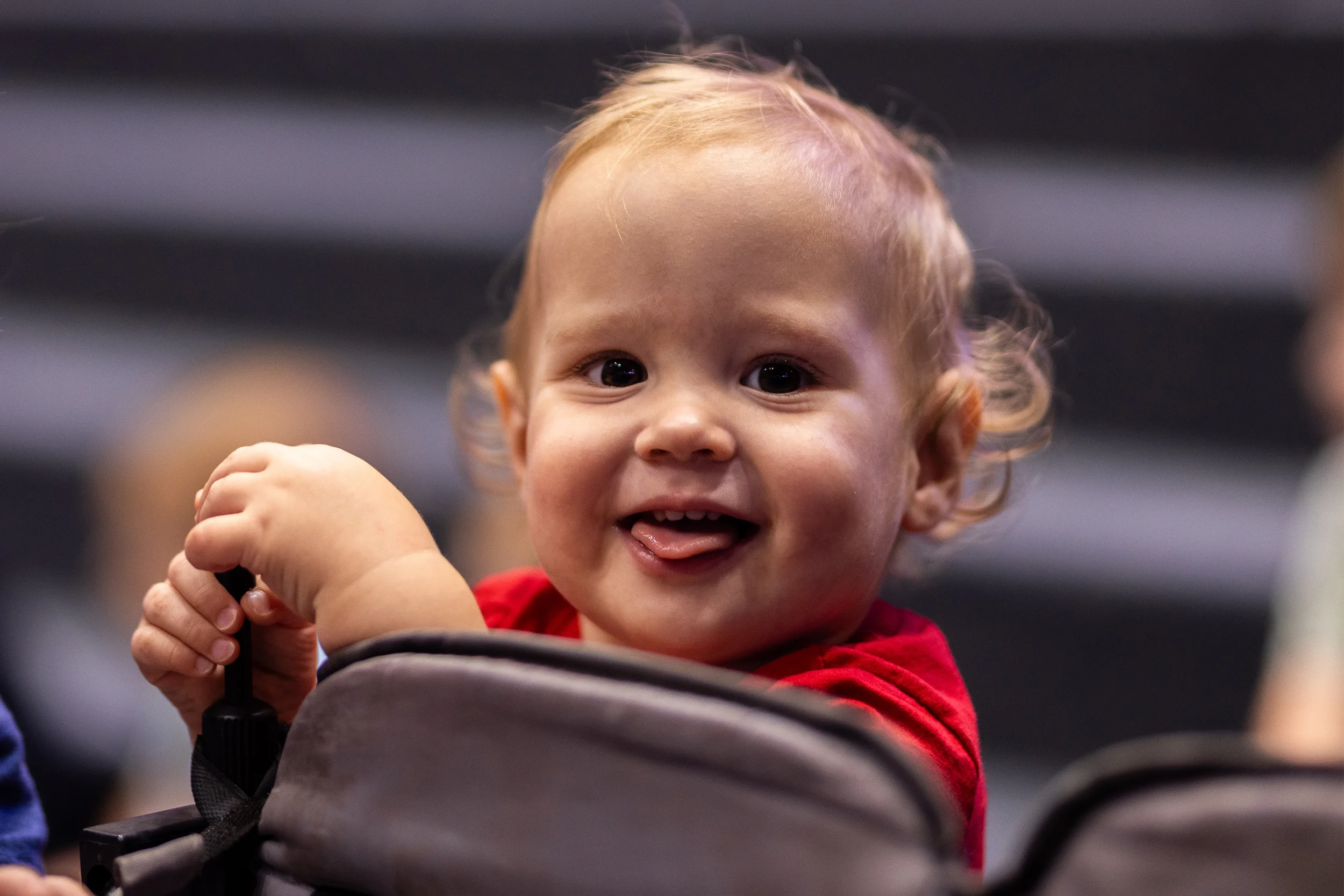 An infant smiling in a stroller in the Strauss ECE infant program