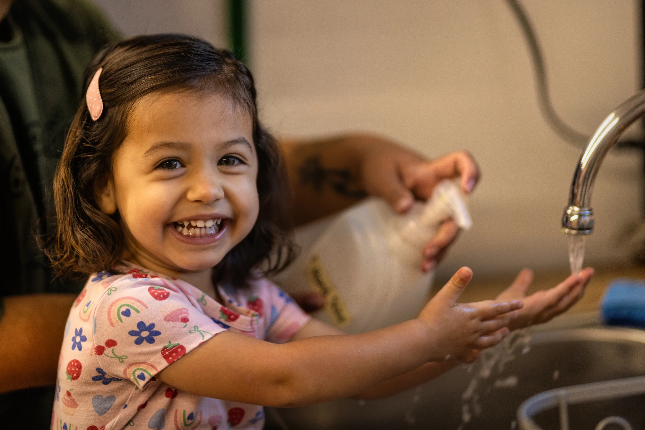 A child washing hands at a classroom sink at Strauss ECE