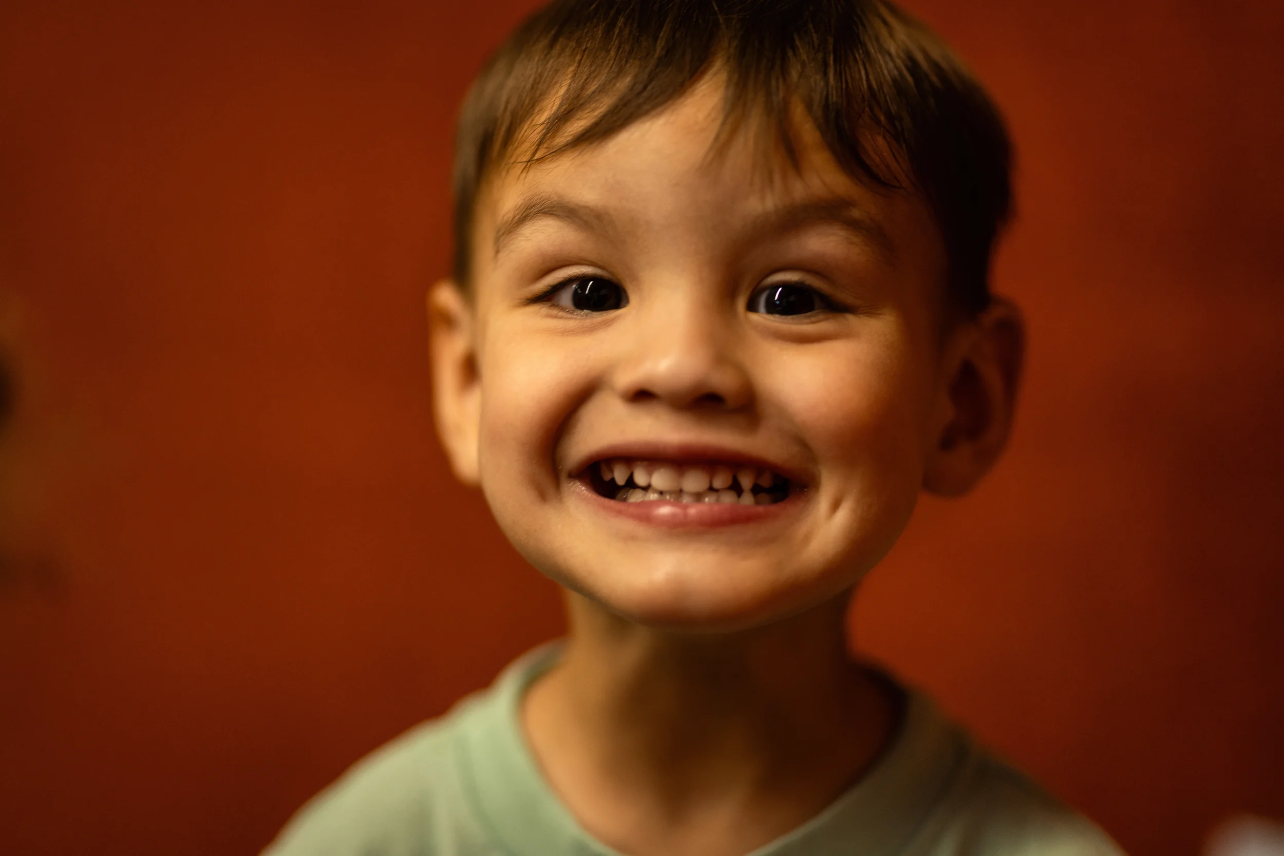 A toddler smiling in class at Strauss ECE in Tucson
