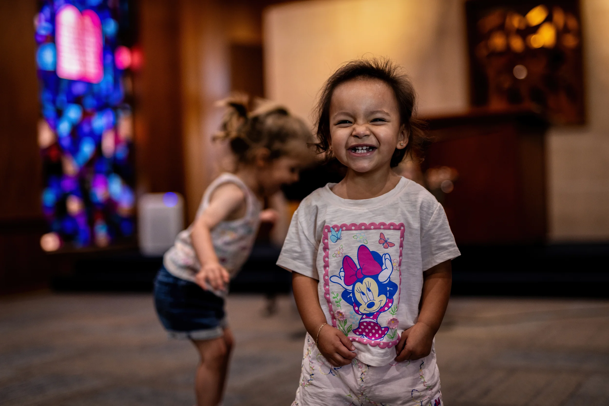 A child smiling during an indoor enrichment activity at Strauss ECE