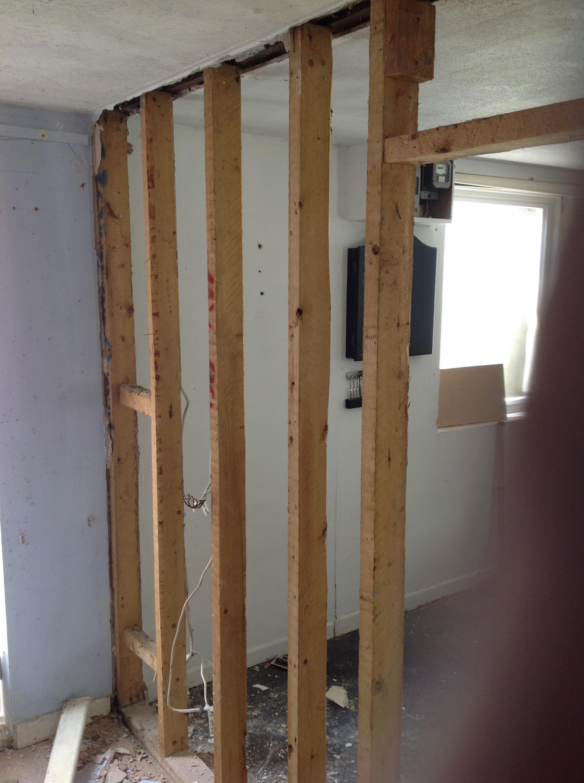 Studs from the kitchen wall were repurposed in the new bathroom, alongside new beams.